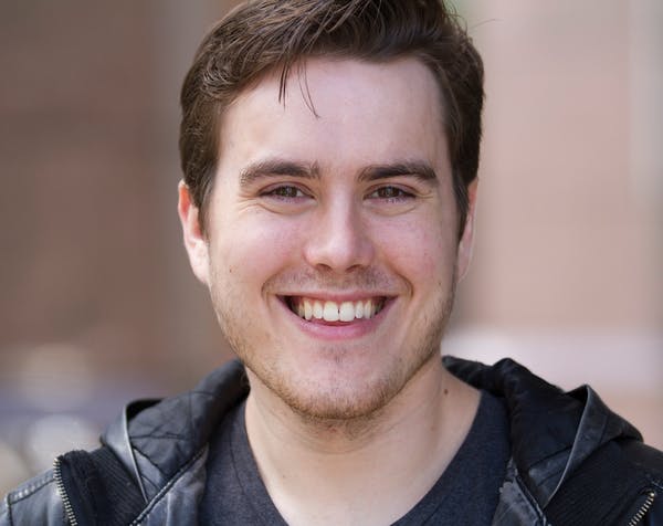 a man wearing glasses and smiling at the camera